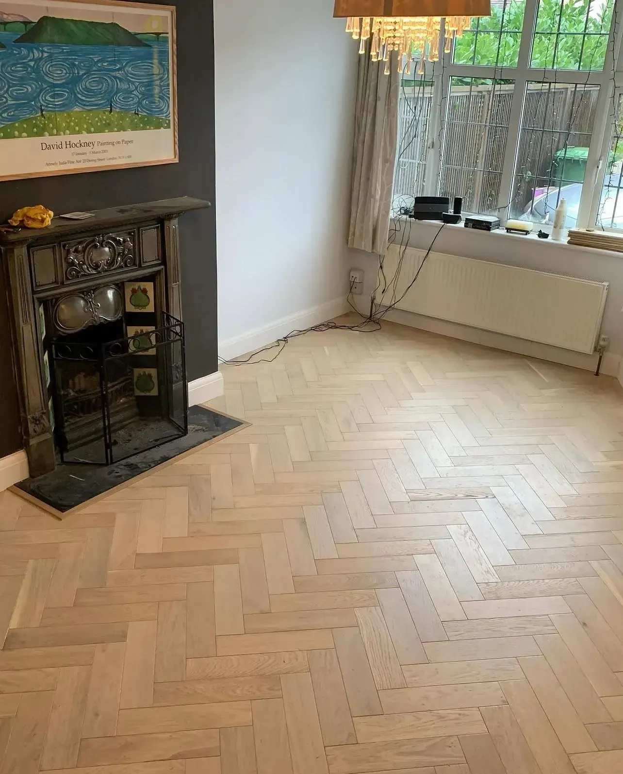 Light oak herringbone wood flooring fitted in a period living room