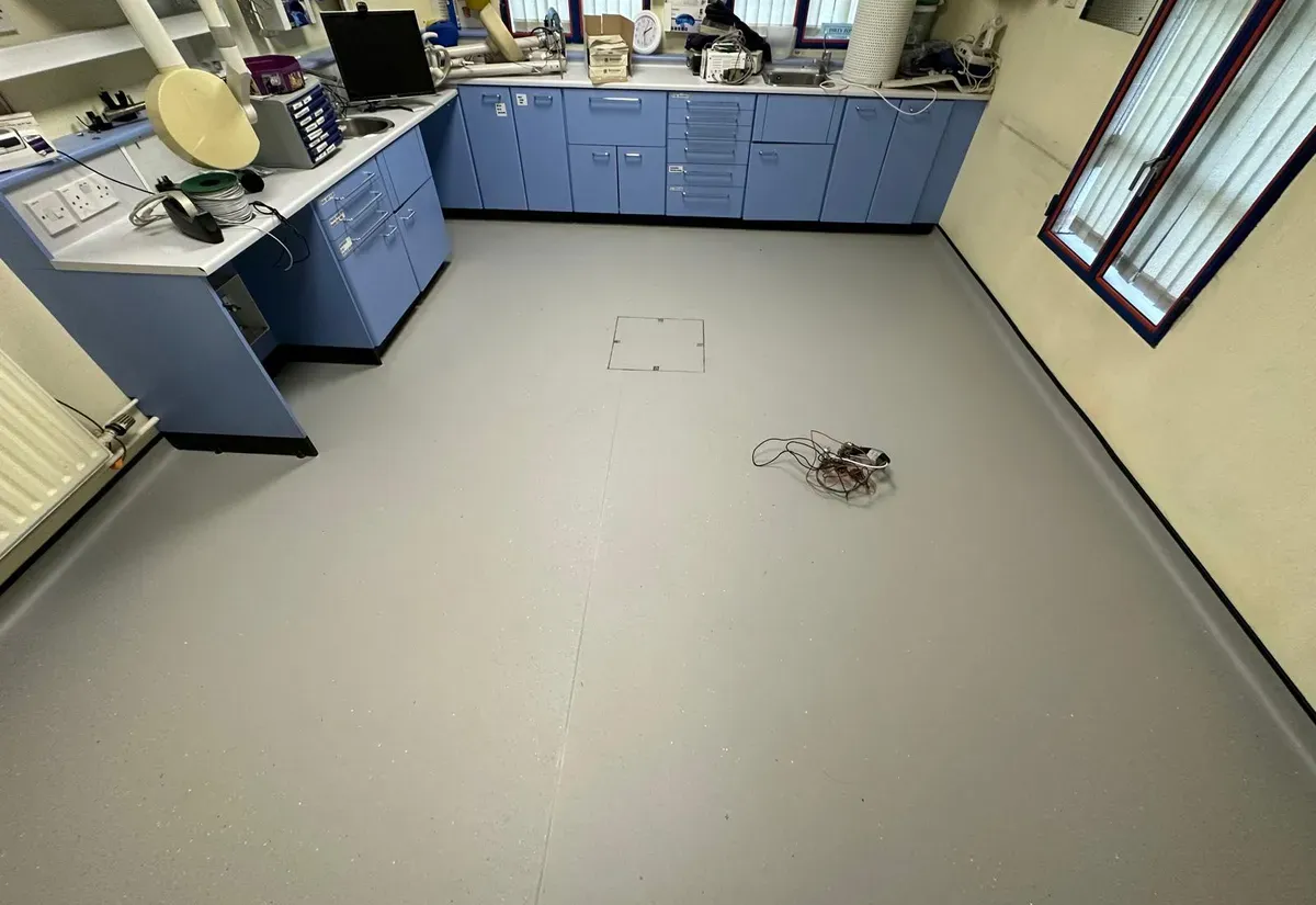 Light-grey slip-resistant safety vinyl with coved edges in a laboratory