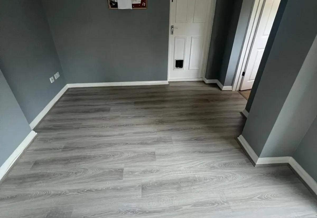 Grey oak-effect laminate flooring fitted in a freshly decorated room