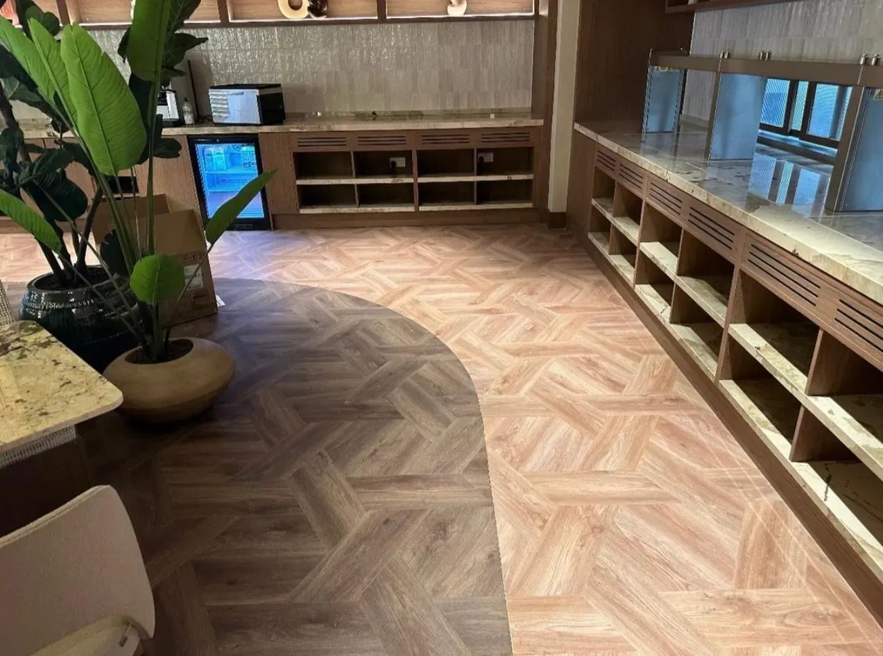 Curved border between two LVT tones at the buffet servery and bar plinth